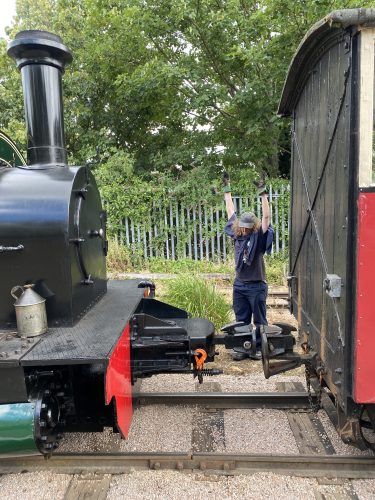 The station master gives the stop hand signal (both hands raised above the head) to the driver of Premier so that the locomotive can be coupled to the train.