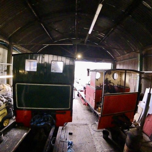 Two steam locomotives stand in the engine shed